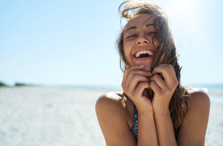 Summer sunny beach portrait with beautiful smiling woman. Hispanic girl laughing and looking at camera with enjoymentの写真素材