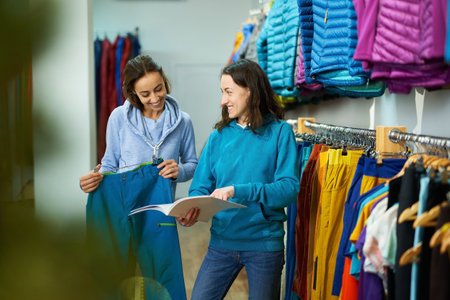 Young woman shopping in clothing store, while a helpful consultant guides her through the latest trends and stylesの写真素材