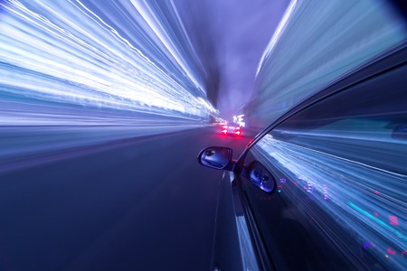 View from Side of Car moving in a night city, Blured road with lights with car on high speed. Concept rapid rhythm of a modern city.の写真素材