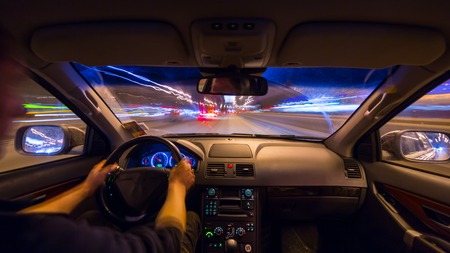City road view from inside car natural light street and other cars is motion blurredの写真素材