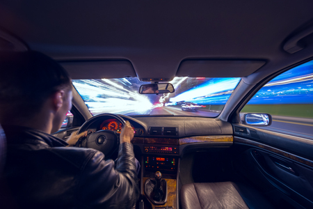 City road view from inside car natural light street and other cars is motion blurredの写真素材