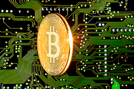 Golden bitcoin cryptocurrency on circuit board backgroundの写真素材