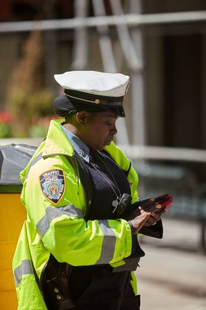 NEW YORK - APRIL 22 2015 Police officers performing his duties on the streets of Manhattan. New York City Police Department (NYPD) is the largest municipal police force in the United Statesのeditorial素材