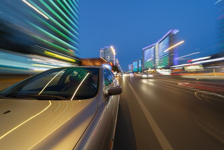 Blurred downtown look from fast driving car to back side and driver at summer twilight. Longexposure shot.の写真素材