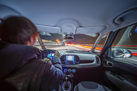 City road view from inside car natural light street and other cars is motion blurredの写真素材