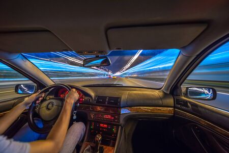 City road view from inside car natural light street and other cars is motion blurredの写真素材