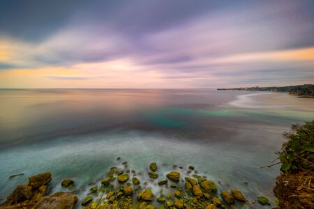 Long exposure dramatic tropical sea and sky sunset, Longexposure shot Colored sky over ocean coast on sunset time background.の写真素材