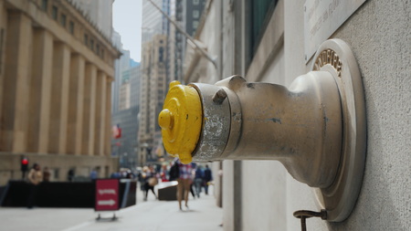 Fire hydrant in the wall of a building on Wall Street in New Yorkの写真素材