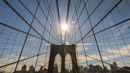 The sun shines over the Brooklyn Bridge in New Yorkの写真素材