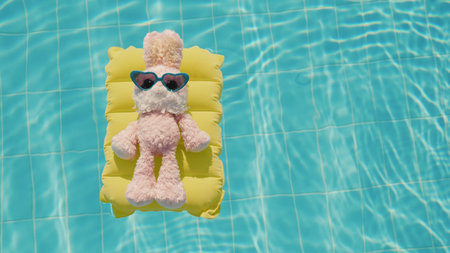 A cool rabbit in sun glasses glows on an inflatable mattress. Floats in the pool. Vacation with...