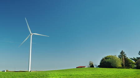 One Industrial wind generator on a green meadow. Alternative sources of clean energy.の写真素材
