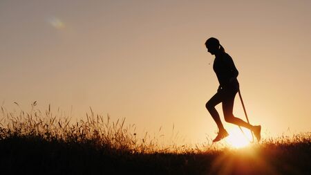 Silhouette of a woman - jumping through the rope at sunsetの写真素材