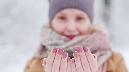 Portrait of a woman who catches snowflakes, sharpness at her fingertipsの写真素材