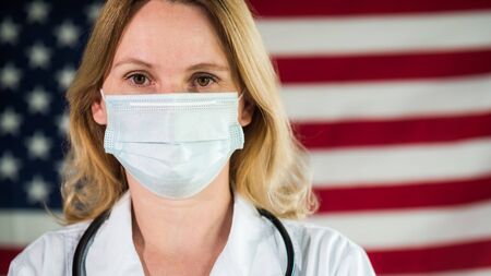 Portrait of a masked woman wearing a U.S. flagの写真素材