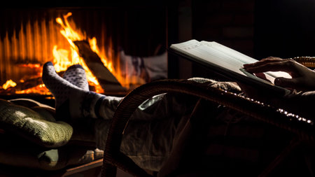 Sitting by the fireplace with a notebook open on a new page. New plans for the New Yearの写真素材