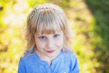 Portrait of a cute blue-eyed girl in a blue shirtの写真素材