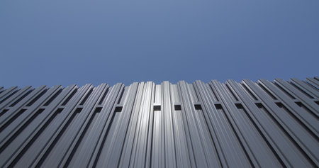 Grey metal shuttle fence against blue skyの写真素材