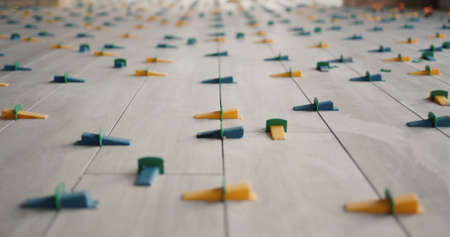 Ceramic tiles, just laid on the floor, in the form of boards, fixed with a leveling systemの写真素材