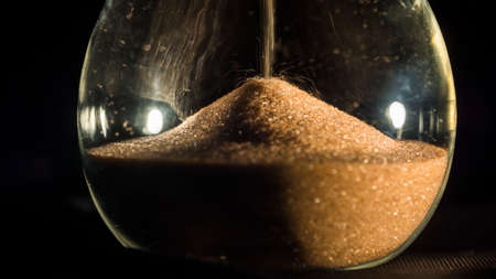 Hourglass close-up on a black backgroundの写真素材