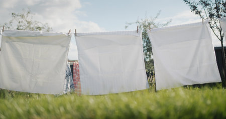 Bed linens are drying in the backyard of the houseの写真素材