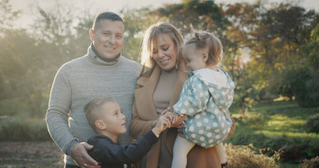 Portrait of a young healthy family - a couple with two children. Smiling, looking at the camera....