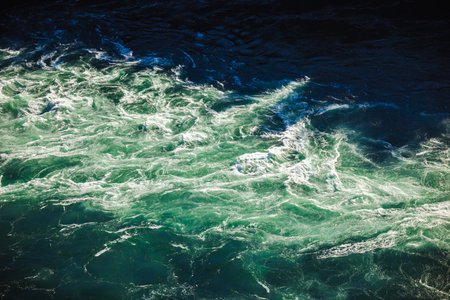 Close-up view of swirling turquoise rapids of the Niagara River with foamy waves and sunlight reflectionsの写真素材