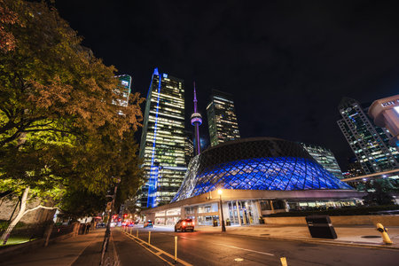 Toronto, Canada, 20 October 2025: Night view of Roy Thomson Hall illuminated in blue, with the CN...