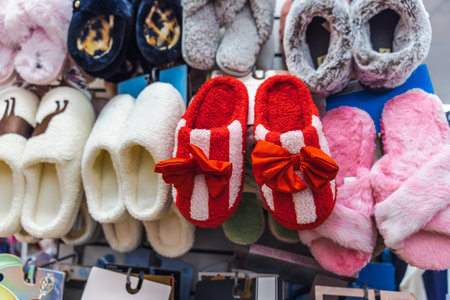 Colorful cozy home slippers displayed on store wall, soft indoor footwear assortment in retail shop...