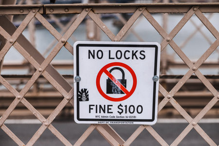 No locks warning sign on New York City bridge fence with fine notice