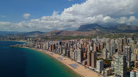 Aerial panoramic view of Benidorm coastline with high rise skyline and sandy Mediterranean beach...
