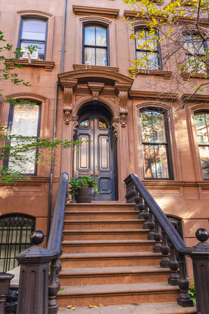 Classic brownstone townhouse entrance with staircase and ornate doorway in New York
