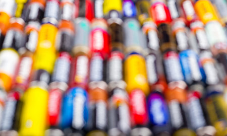 Battery AA texture blurred in a row. Defocused rows of batteries, perspective view. Multicolored...
