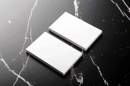 Photo of white business cards on black marble. Template for branding identity isolated on marble background. For graphic designers presentations and portfolios marble premium luxury mock-up. Business Card isolated on marble stone.の写真素材