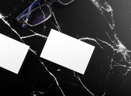 Photo of white business cards on black marble. Template for branding identity isolated on marble background. For graphic designers presentations and portfolios marble premium luxury mock-up. Business Card isolated on marble stone.の写真素材