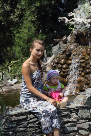 The girl and the child sitting about fallsの写真素材