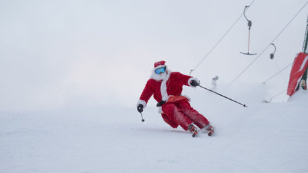 Santa Claus alpine skier skiing downhill in snowy forest ski resort slope Christmas sport lifestyle celebrationの写真素材