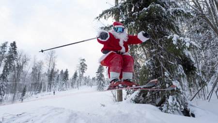 Santa Claus alpine skier skiing downhill jump in snowy forest ski resort slope Christmas sport lifestyle celebrationの写真素材