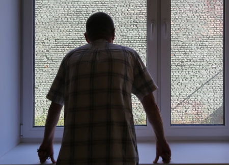 The man in black looks out the windowの写真素材