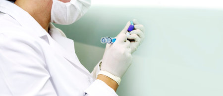 A nurse in a laboratory takes a blood test from a patient