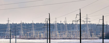 High voltage towers in winter with sky background.