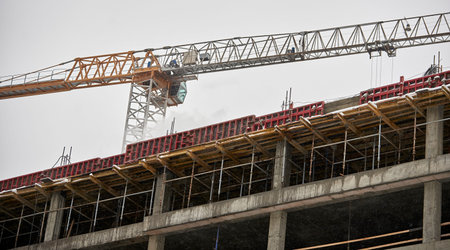 the construction crane and the building against the blue sky