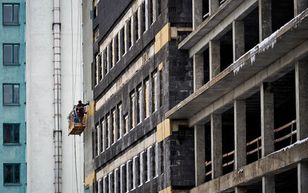 a construction worker makes a structure for a ventilation facadeの写真素材