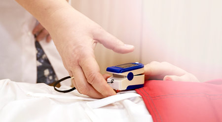 Pulse oximeter on the patients hand. Surgery equipment