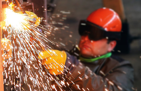 Sparks and drops of molten metal during work of welder.