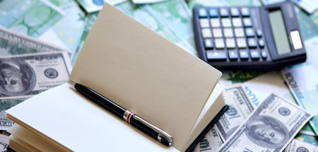 Notepad and pen, dollar and euro on the table. Exchange of dollars and euros.の写真素材