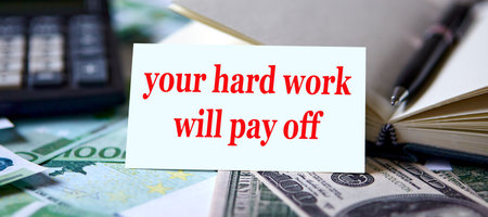 Card with the inscription Your hard work will pay off against the background of a calculator and money.の写真素材