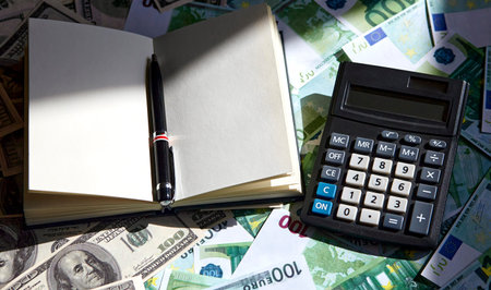 Notepad and pen, dollar and euro on the table. Exchange of dollars and euros.の写真素材