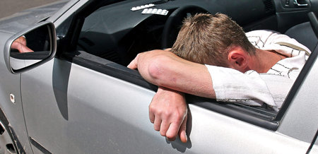 Close-up of a young man taking pills in his car. Pill overdose while driving.