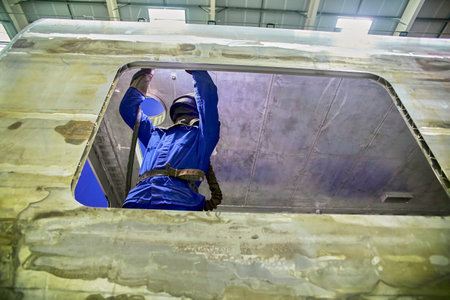 Workshop for assembling metal frames for subway cars, trams and trains. Welders assemble body parts.