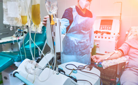 A young man as a blood donor at a donation with his hand clenched into a fist. Collection of blood plasma.の写真素材